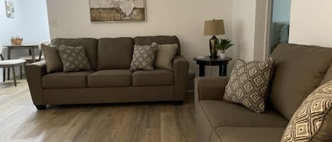 Living room with couch, loveseat, end table, table & floor lamp, chair, TV