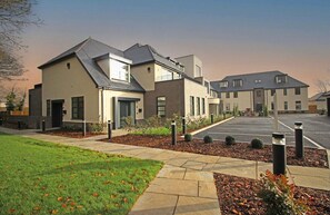 A glimpse of the exterior of our property, showcasing the blend of modern design and accessible parking within a pleasant environment.