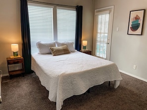 In the primary bedroom, after a restful sleep, you can wake up with access to the ensuite porch to enjoy the quiet morning ambiance and a cup of coffee.
