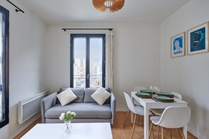 Salon avec cuisine américaine et coin repas