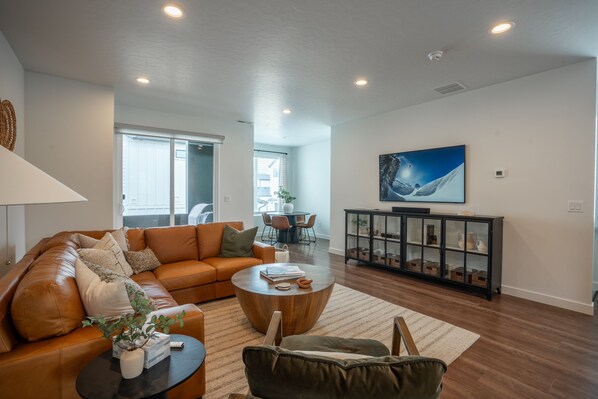 Main living area with top grain leather couch and 65" Samsung Frame TV