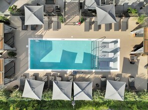 Communal Area: Sparkling blue pool with covered cabanas, sun loungers, and a wheelchair lift.