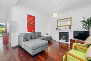 Relax and unwind in this spacious living area, featuring a comfortable sectional sofa, a cozy fireplace, and hardwood floors that add a touch of warmth.