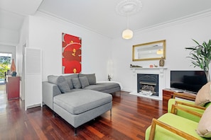 Relax and unwind in this spacious living area, featuring a comfortable sectional sofa, a cozy fireplace, and hardwood floors that add a touch of warmth.