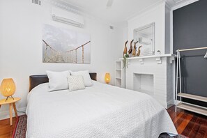 Rest in this cozy bedroom, featuring a comfortable bed, soft linens, and a touch of natural light.