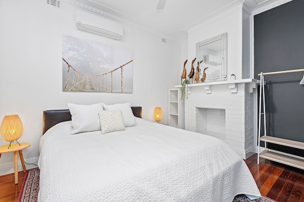 Rest in this cozy bedroom, featuring a comfortable bed, soft linens, and a touch of natural light.