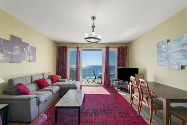 Living Area with Ocean Views, Flat Screen TV, Dining Area, and Private Balcony Access