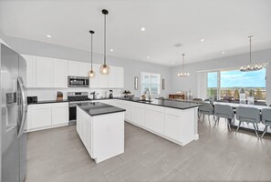Streamlined for both function and entertaining, allowing guests to cook, chat, and dine together in a seamless space.