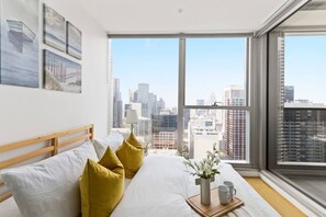 The master bedroom with a double sized bed & city views.