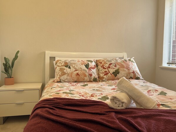 Sink into the plush bedding and drift off to sleep in this inviting bedroom. The soft colors and floral patterns create a peaceful atmosphere.
