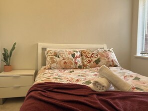 Sink into the plush bedding and drift off to sleep in this inviting bedroom. The soft colors and floral patterns create a peaceful atmosphere.