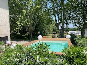 Heated swimming pool with full-width steps and a bar with stools running the length of the pool.