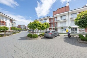 An exterior view of the residential complex showcasing landscaped areas and parking.

