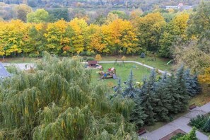 A beautiful park view with autumn-colored trees and a children’s playground.

