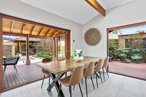 Open plan dining and living area with doors that open out to the alfresco area and pool. 