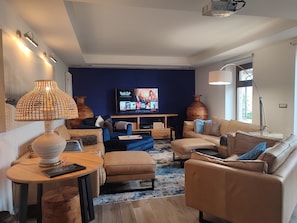 Lounge with soft, genuine leather sofas, 65" Smart TV and  Home Theater system.