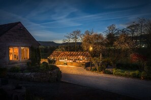 summer house and driveway lit up at night