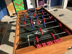 GAME ROOM – The game room is filled with exciting options for relaxation and fun. In addition to the classic foosball table, guests can enjoy air hockey, checkers, and a baseball strategy game. The room's cozy lounge area, complete with plush sofas and stylish decor, makes it the perfect spot to unwind and socialize after a day of exploring. Ideal for both kids and adults, this...