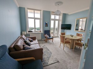 Living room, sofa for 3, 2 easy chairs and dining table with 4 chairs. Sea views