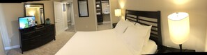 Bedroom with Queen bed, dresser, mirror, walk-in closet and flat screen TV