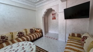 living room has 3big sofas that extra people use as a bed