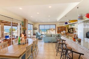 Dining area in foreground. Living area at the back. Kitchen island to the right