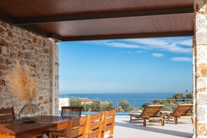 Outdoor dining  area for 8 under a shaded pergola offers ample chance for al fresco dining.