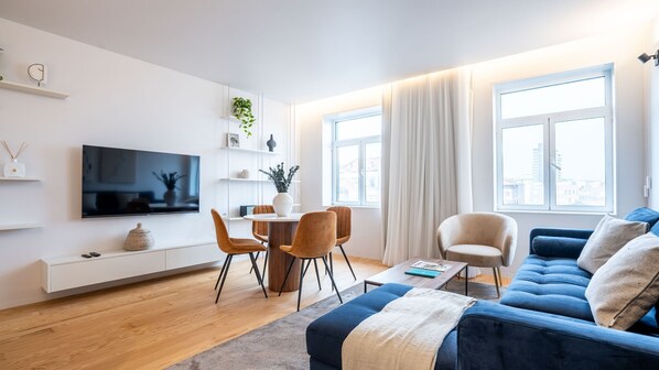 Spacious living area with a large, comfortable sofa, dining table, TV, and abundant natural light flowing in from the balcony.
#comfort