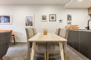 Open-plan living means the lounge room and kitchen sit alongside a wooden dining table for up to four guests