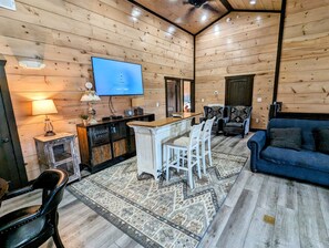 Upper level living area with TV, poker table & high ceiling. 