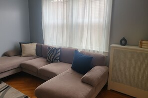 Second seating area with plush sofa and natural sunlight.