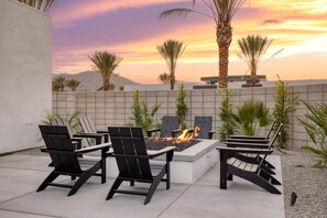 Entertainer's backyard with a pool, hot tub, patio lounge, and firepit.