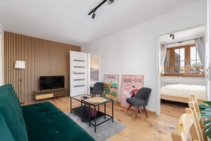 Living room with a double sofa bed, TV and dining area