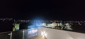 Nighttime city view from shared top floor terrace