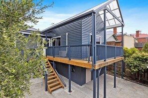 Admire the charming exterior of this residence, featuring an exposed brick façade and an elaborate timber-posted verandah.