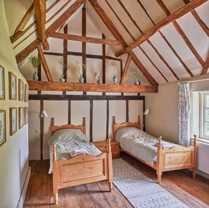 Tall twin bedroom is dressed in a botanical theme. The original elm flooring and beams will take you back 300 years, nothing is straight in this room!