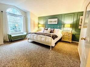 Spacious primary suite with king sized bed and 55” TV.