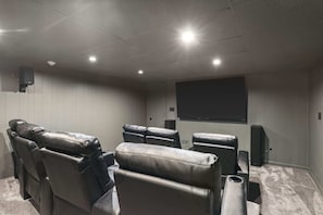 Theater seating with 85" smart TV in the basement