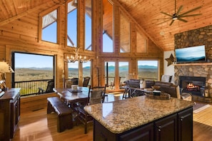 Open concept living space with floor to ceiling windows and gas fireplace