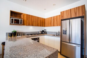 Fully-equipped kitchen with high-end amenities like fridge, stove, oven and microwave