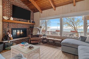 The living room has lots of comfortable seating, a fireplace and flat-screen TV.