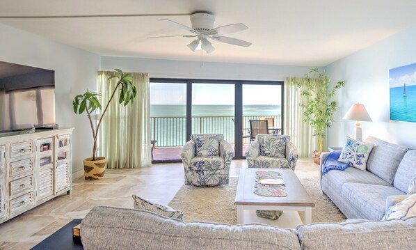 Living room with sofa bed, large tv, balcony and ocean views