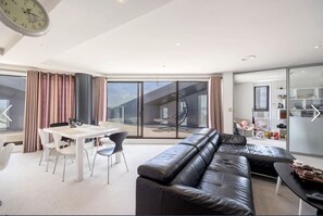 Spacious living room, TV, sofa, balcony.