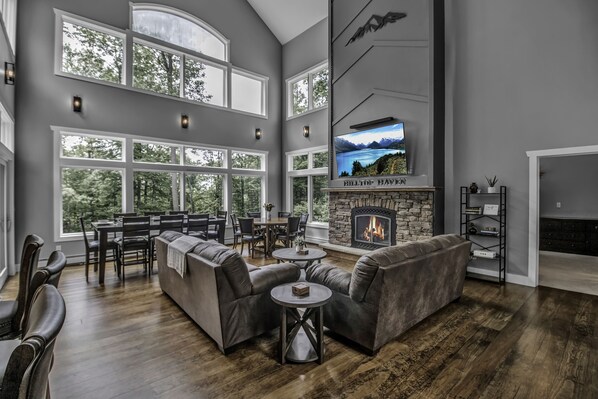 Enjoy this open living room and dining room overlooking over 6 wooded acres.