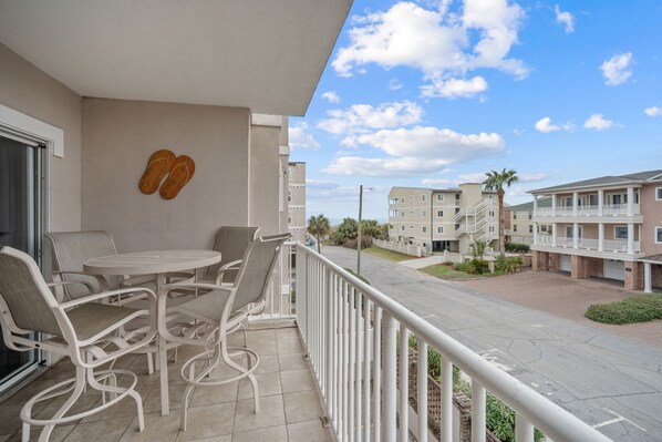 Balcony with ocean view (side); table with seating for four and two addl chairs