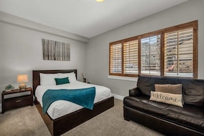 The master bedroom is a peaceful retreat with a queen-size bed, a cozy leather couch and an ensuite bathroom.