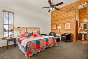 Charming king suite adorned with vaulted ceilings, shiplap walls, and a cozy sitting area, promising a serene retreat.