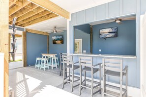 Enjoy the ambiance of the porch, complete with a bar and chairs. Perfect spot for relaxation and good company.