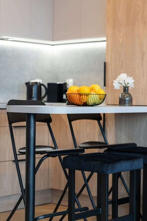 Compact dining area with black bar stools and under-cabinet lighting.
