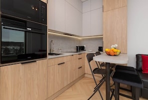 Kitchen with wooden cabinets, built-in oven, and modern appliances.
